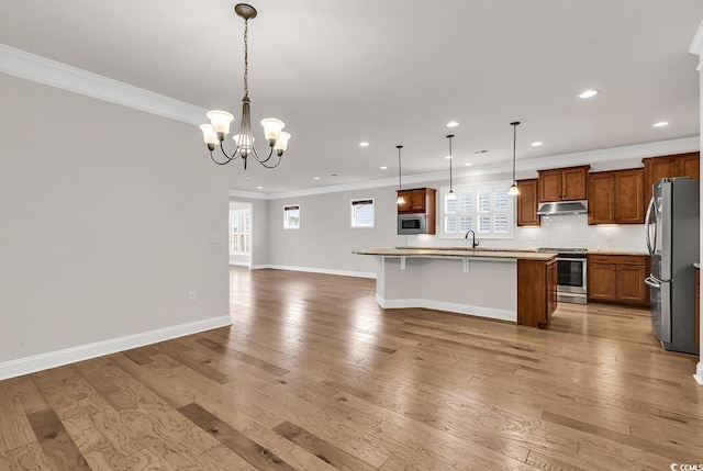 kitchen featuring a wealth of natural light, light hardwood / wood-style flooring, an island with sink, and stainless steel appliances