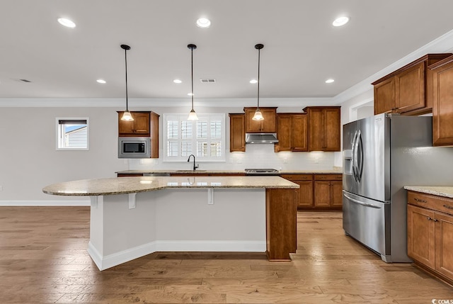 kitchen featuring stainless steel appliances, a kitchen island, and light hardwood / wood-style flooring