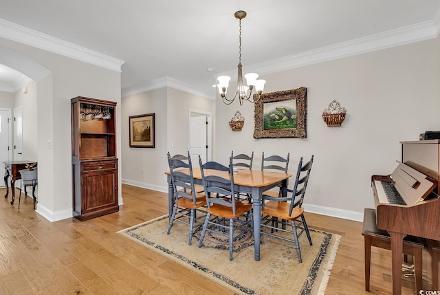 dining room featuring light hardwood / wood-style floors, crown molding, and a notable chandelier