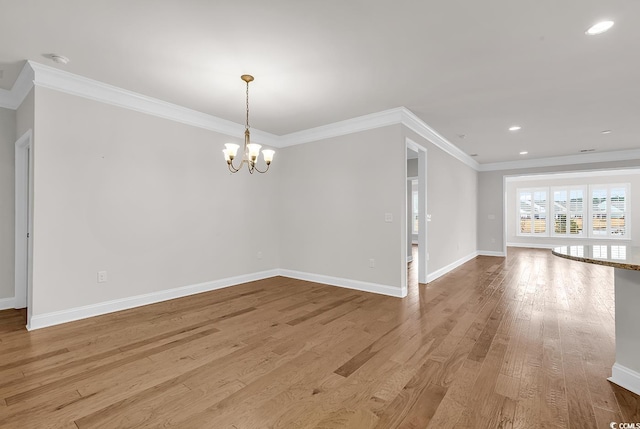 unfurnished room with crown molding, light hardwood / wood-style flooring, and a chandelier