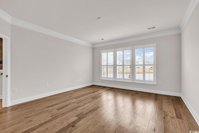 spare room featuring light wood-type flooring and crown molding