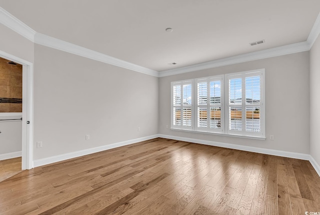 spare room with light wood-type flooring and ornamental molding