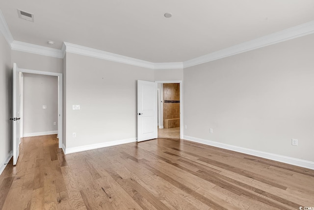 spare room with ornamental molding and light wood-type flooring