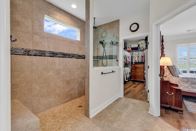 bathroom featuring hardwood / wood-style floors, tiled shower, and a wealth of natural light