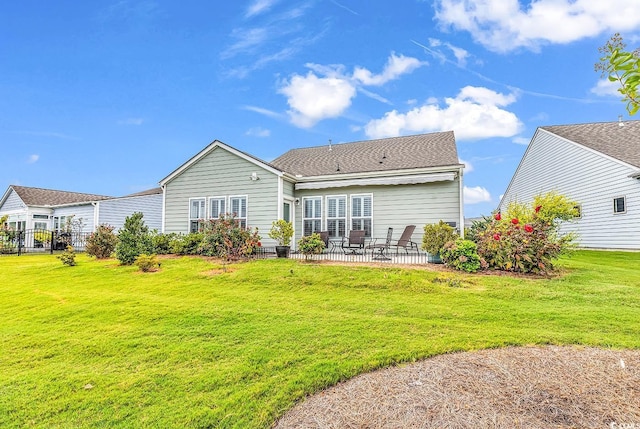 rear view of house with a yard and a patio