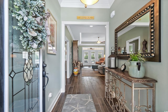 foyer entrance with crown molding, dark wood-type flooring, ceiling fan, and a tray ceiling