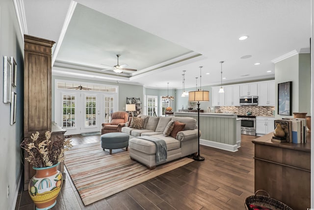 living room featuring french doors, crown molding, dark wood-type flooring, ceiling fan, and a raised ceiling