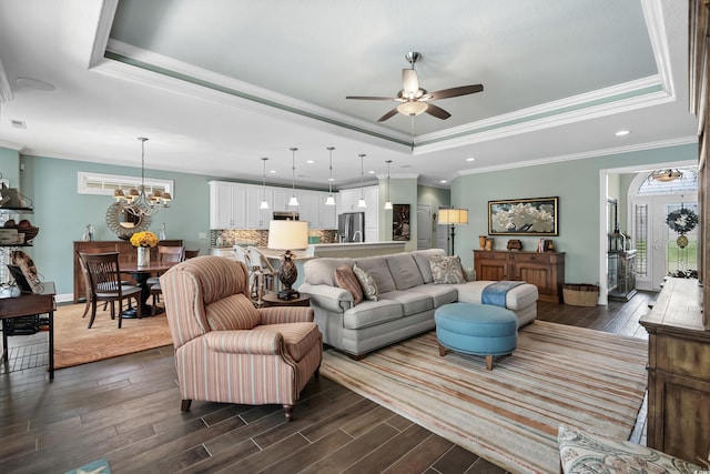 living room with dark hardwood / wood-style floors, crown molding, and a tray ceiling