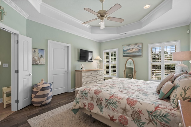 bedroom featuring ceiling fan, crown molding, dark hardwood / wood-style floors, and a tray ceiling