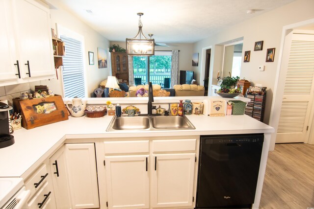 kitchen with hanging light fixtures, light wood-type flooring, sink, black dishwasher, and kitchen peninsula