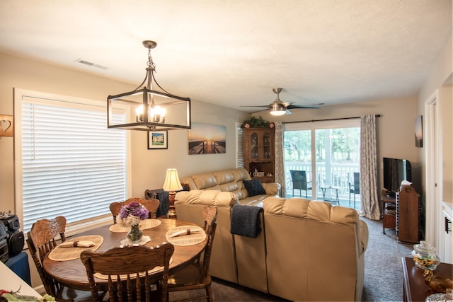 dining area with carpet floors and ceiling fan with notable chandelier