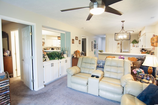 living room featuring ceiling fan with notable chandelier and light colored carpet