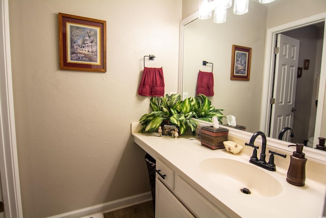 bathroom featuring wood finished floors, vanity, and baseboards