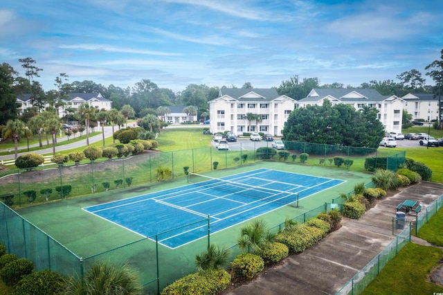 view of sport court with a residential view and fence