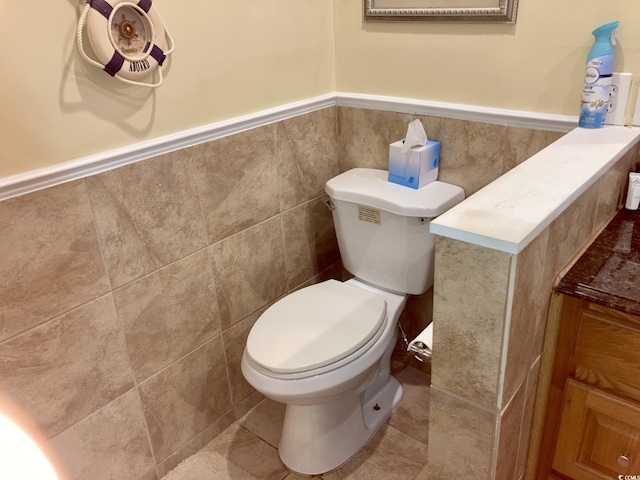 bathroom with tile walls, tile patterned floors, and toilet