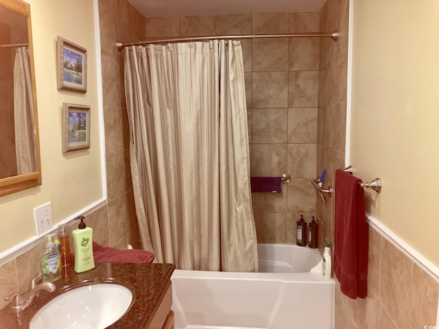 bathroom featuring vanity, tile walls, and shower / bathtub combination with curtain