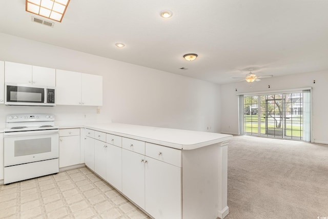 kitchen with white cabinets, kitchen peninsula, light carpet, white electric stove, and ceiling fan