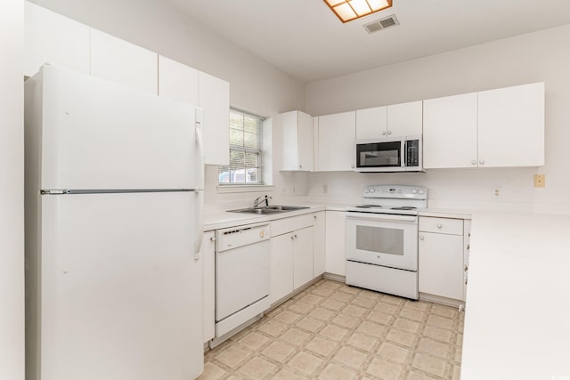 kitchen featuring sink, white appliances, and white cabinetry