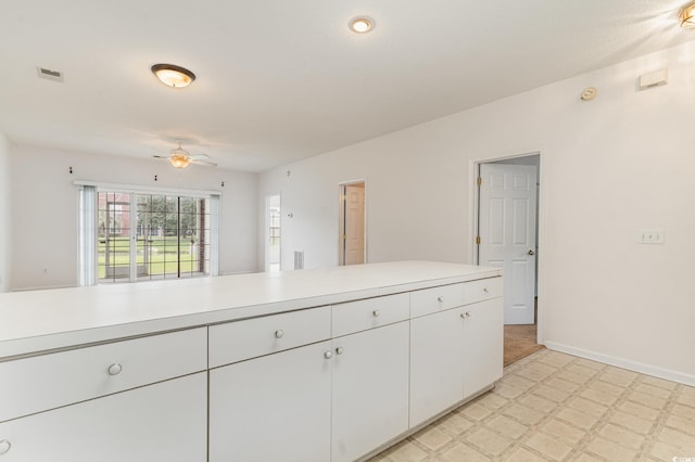 kitchen featuring white cabinets and ceiling fan