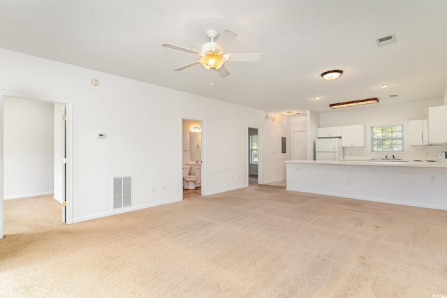 unfurnished living room featuring ceiling fan and light colored carpet