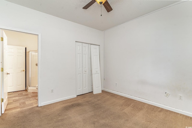 unfurnished bedroom featuring ceiling fan, light colored carpet, and a textured ceiling