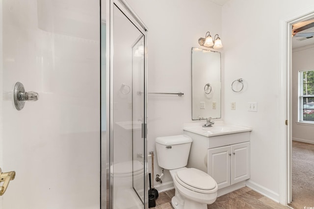 bathroom featuring vanity, a shower with shower door, and toilet