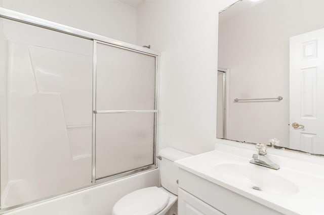 full bathroom with enclosed tub / shower combo, vanity, and toilet