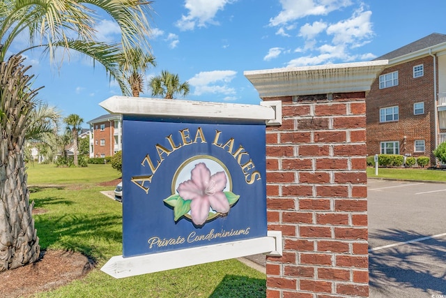 community / neighborhood sign featuring a lawn