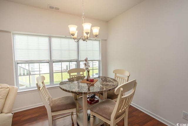 dining room with dark wood-type flooring and a chandelier