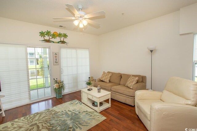 living room featuring ceiling fan and dark wood-type flooring