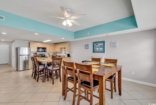 dining space with light tile patterned floors, ceiling fan, recessed lighting, baseboards, and a tray ceiling