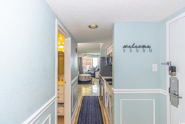 corridor with tile patterned flooring and a textured ceiling