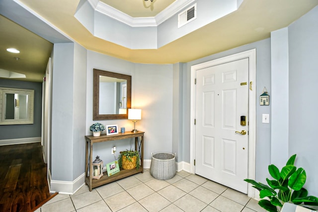 foyer with ornamental molding, visible vents, baseboards, and light tile patterned floors