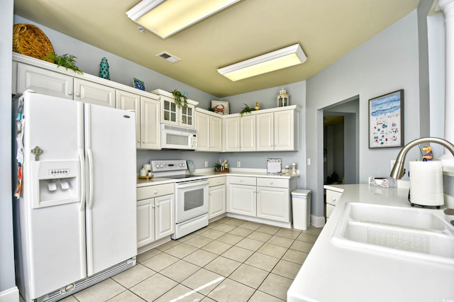 kitchen with light tile patterned floors, light countertops, visible vents, a sink, and white appliances