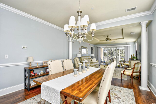 dining room featuring dark hardwood / wood-style flooring, ceiling fan with notable chandelier, ornate columns, a tray ceiling, and ornamental molding