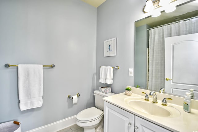 bathroom featuring toilet, vanity, baseboards, and tile patterned floors