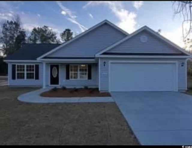 single story home featuring concrete driveway and an attached garage