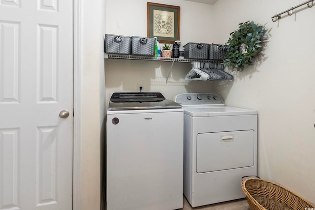 clothes washing area featuring light tile patterned floors and washing machine and clothes dryer