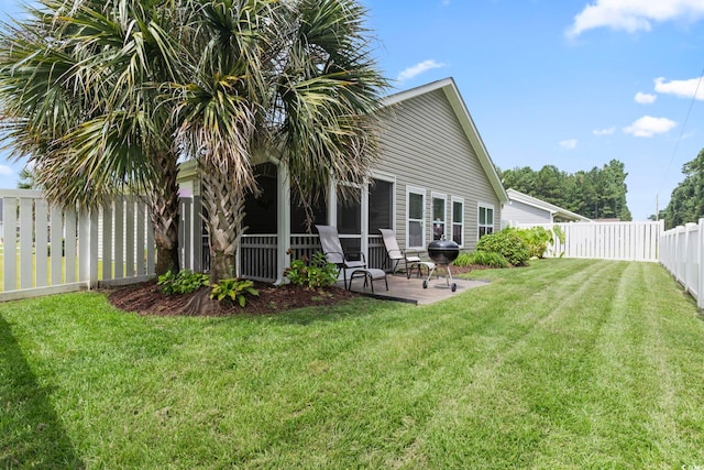 rear view of house with a lawn and a patio