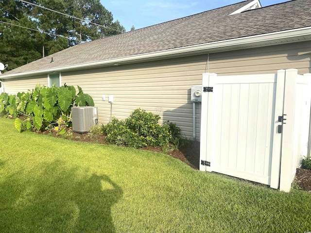 view of side of home with central air condition unit and a lawn