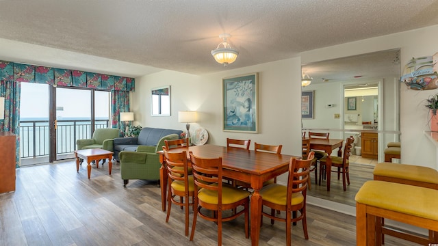 dining room with a textured ceiling and hardwood / wood-style floors