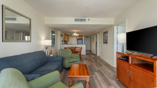 living room featuring wood-type flooring and a textured ceiling