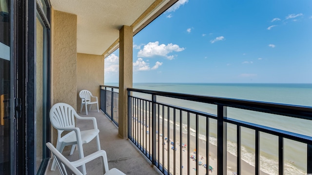 balcony with a water view and a beach view