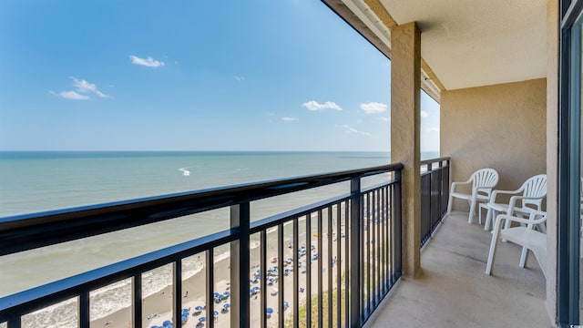 balcony featuring a water view and a view of the beach