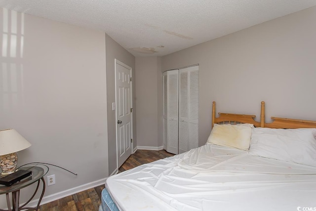 bedroom featuring a textured ceiling, dark hardwood / wood-style flooring, and a closet