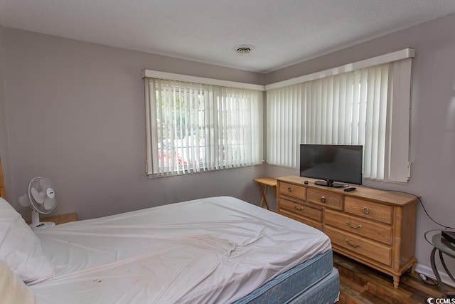 bedroom with dark hardwood / wood-style floors