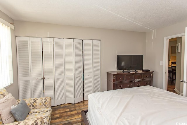 bedroom featuring dark hardwood / wood-style flooring, a textured ceiling, and a closet