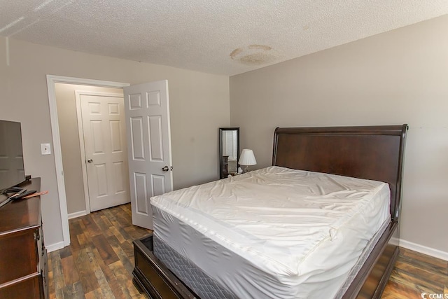 bedroom featuring a textured ceiling and dark hardwood / wood-style floors