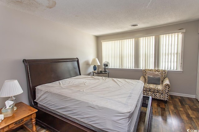 bedroom featuring dark wood-type flooring and a textured ceiling