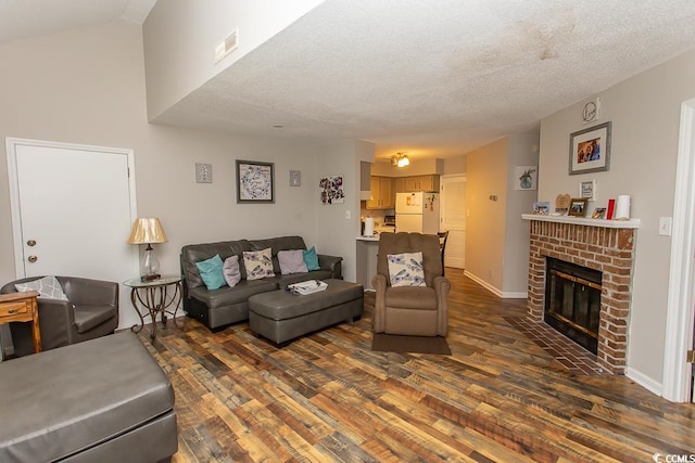 living room with dark hardwood / wood-style flooring, a fireplace, and a textured ceiling